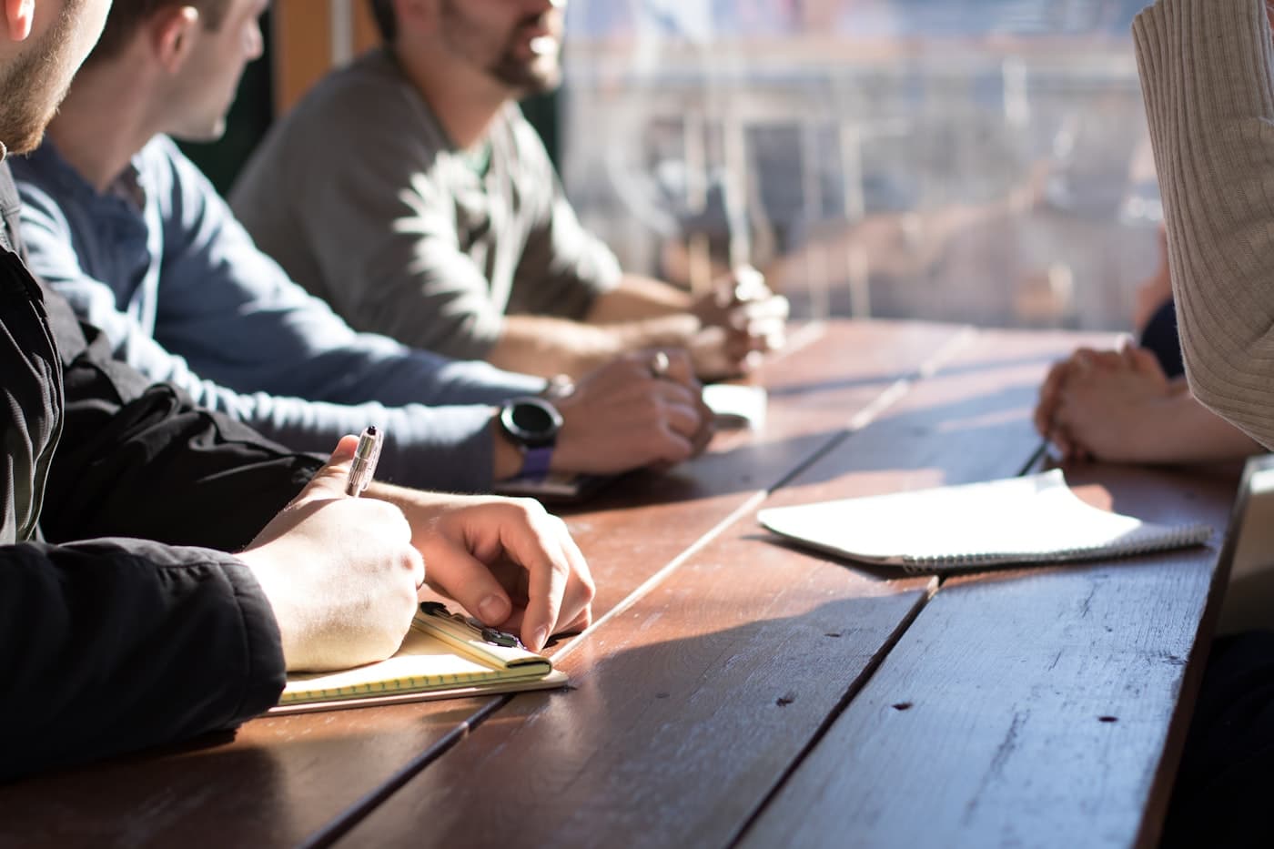 Equipe em reunião de consultoria anotando ideias